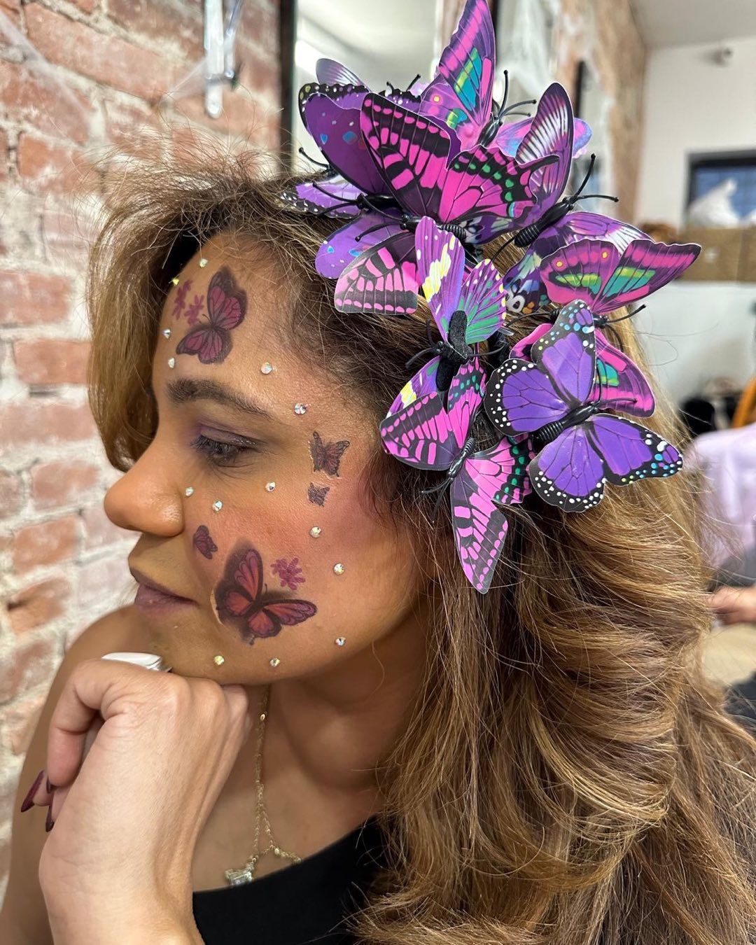 A woman with purple butterflies painted on her face.