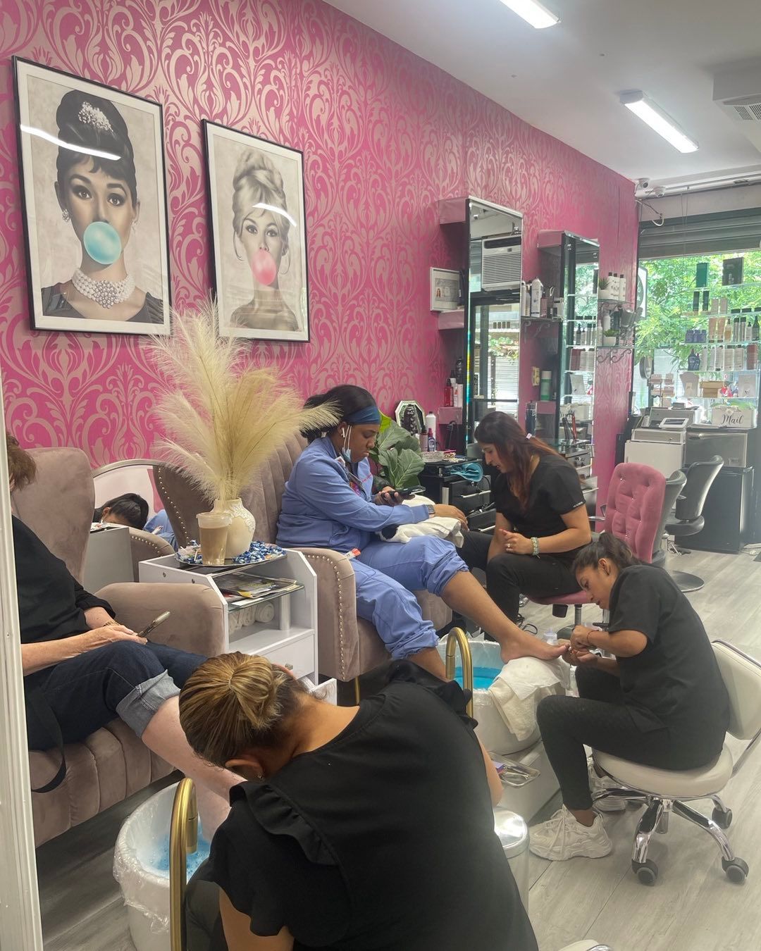 A group of people are sitting in a nail salon getting their nails done.