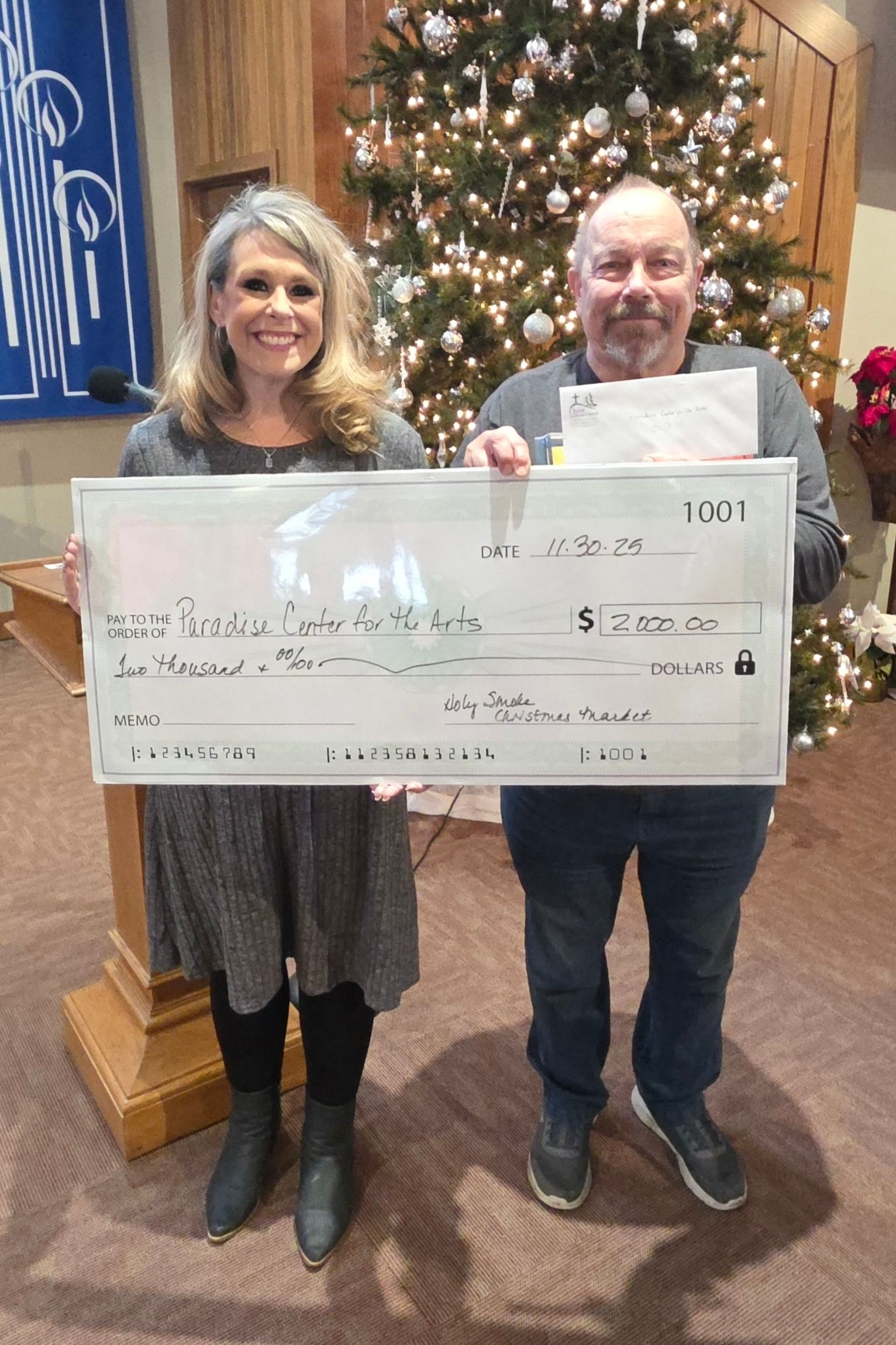 Two board members holding a donation check