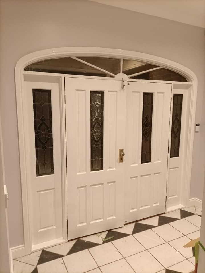 Painter with Cap and Gloves Using Paint Roller and Vintage Ladder to Paint Wall from Behind — Painters in Singleton, NSW