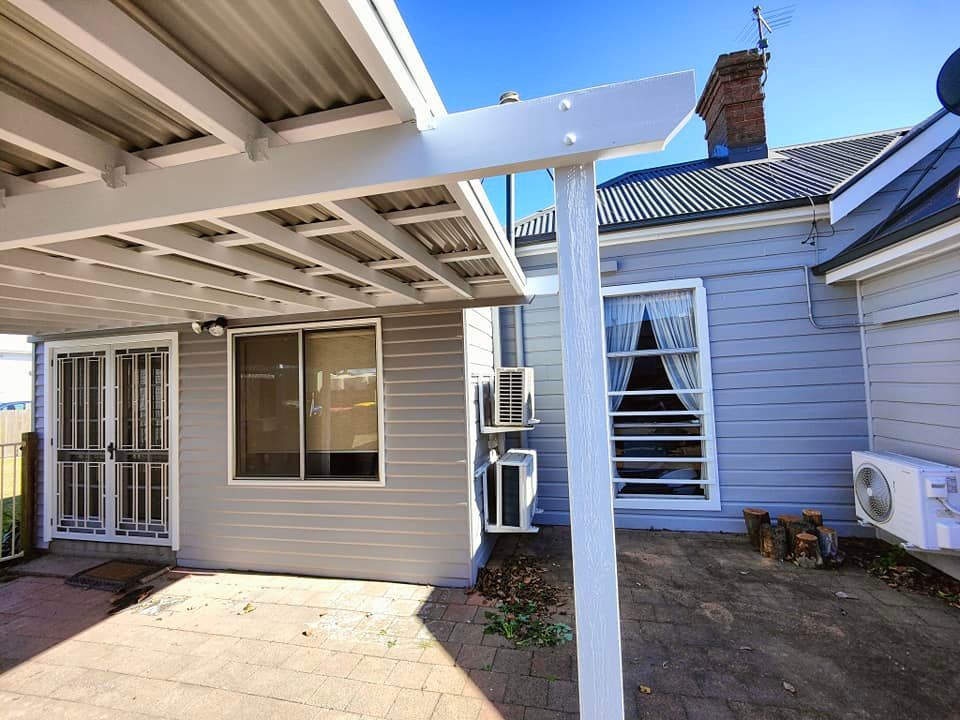 House Painter Painting Building Exterior with Roller — Painters in Muswellbrook, NSW