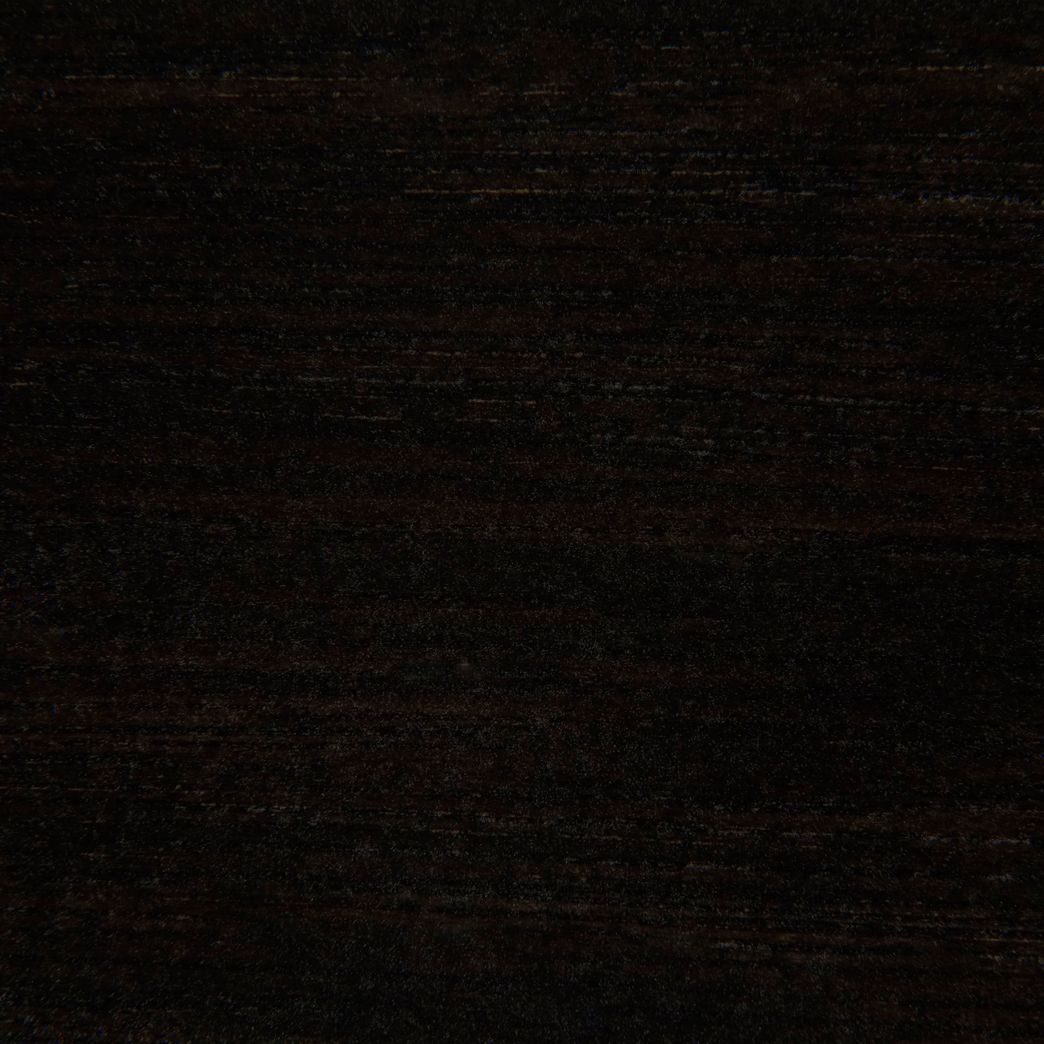A close up of a black wood grain texture.