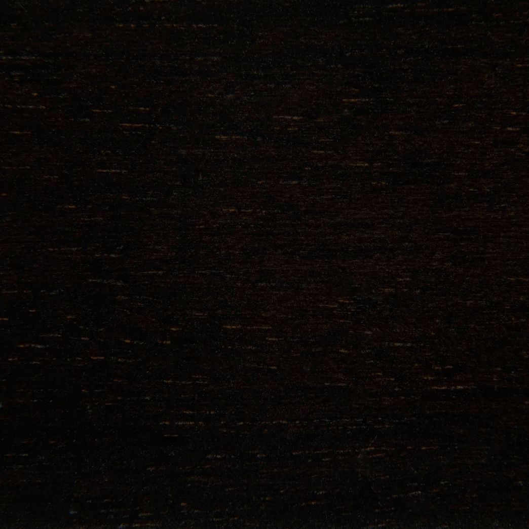 A close up of a black wood grain texture.