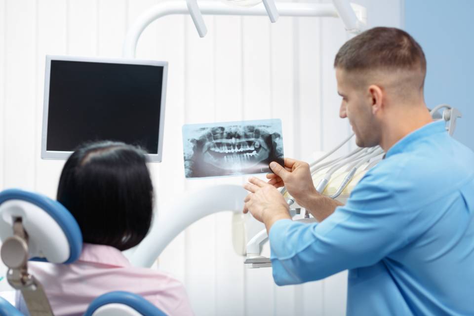 dottore mostra una radiografia dentale