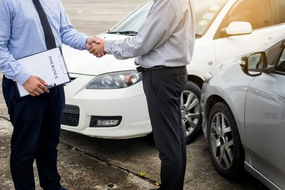 Two Men Shaking Hands Near Damaged Cars — SSP Insurance In Mackay, QLD