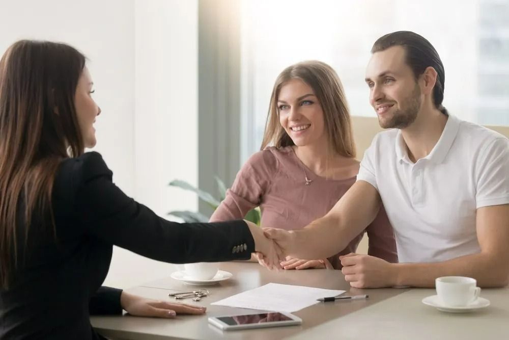 Woman Shaking Hands With a Couple at a Table — SSP Insurance In Rockhampton City, QLD
