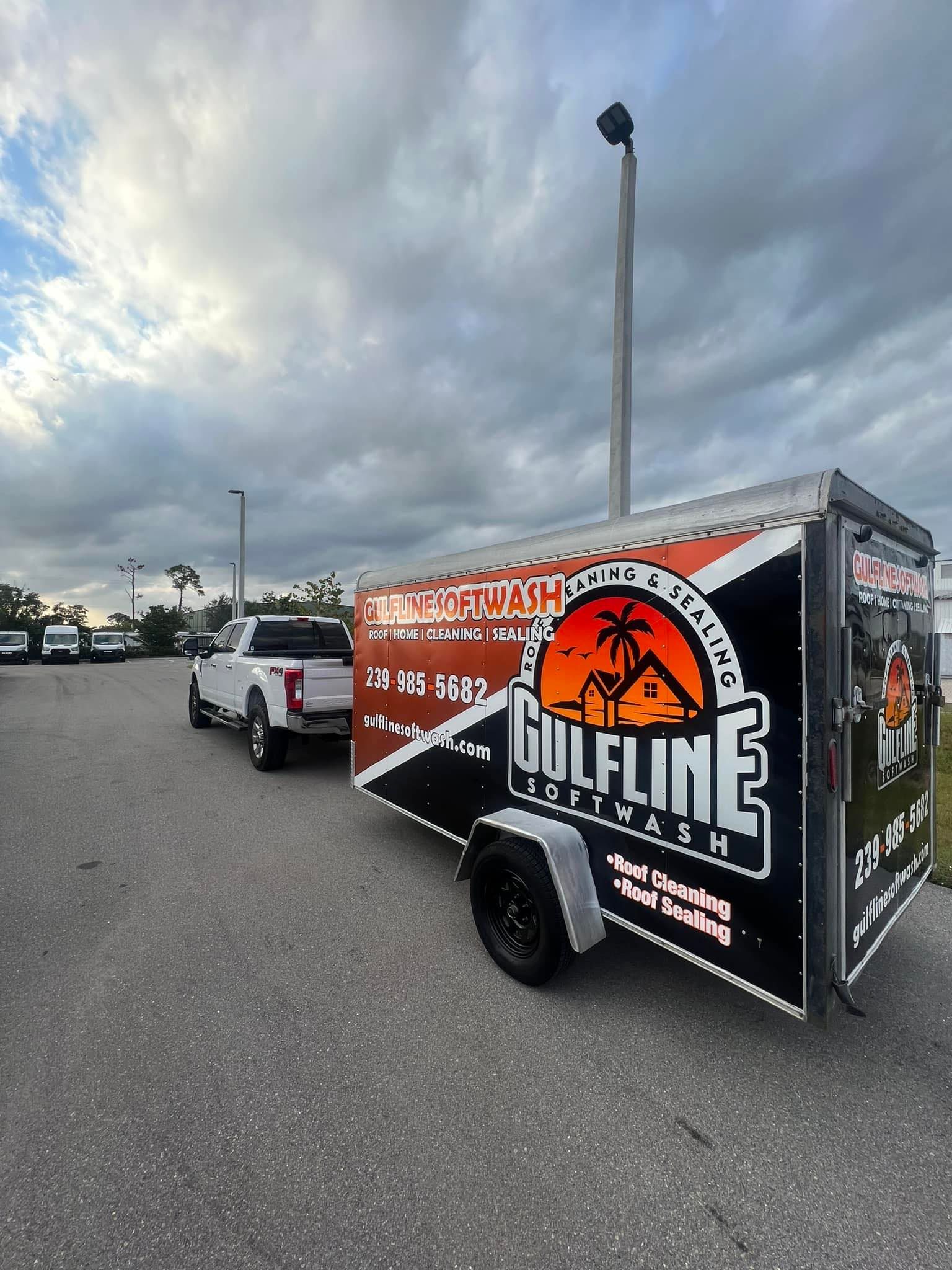 A gulfline trailer is being towed by a truck in a parking lot.