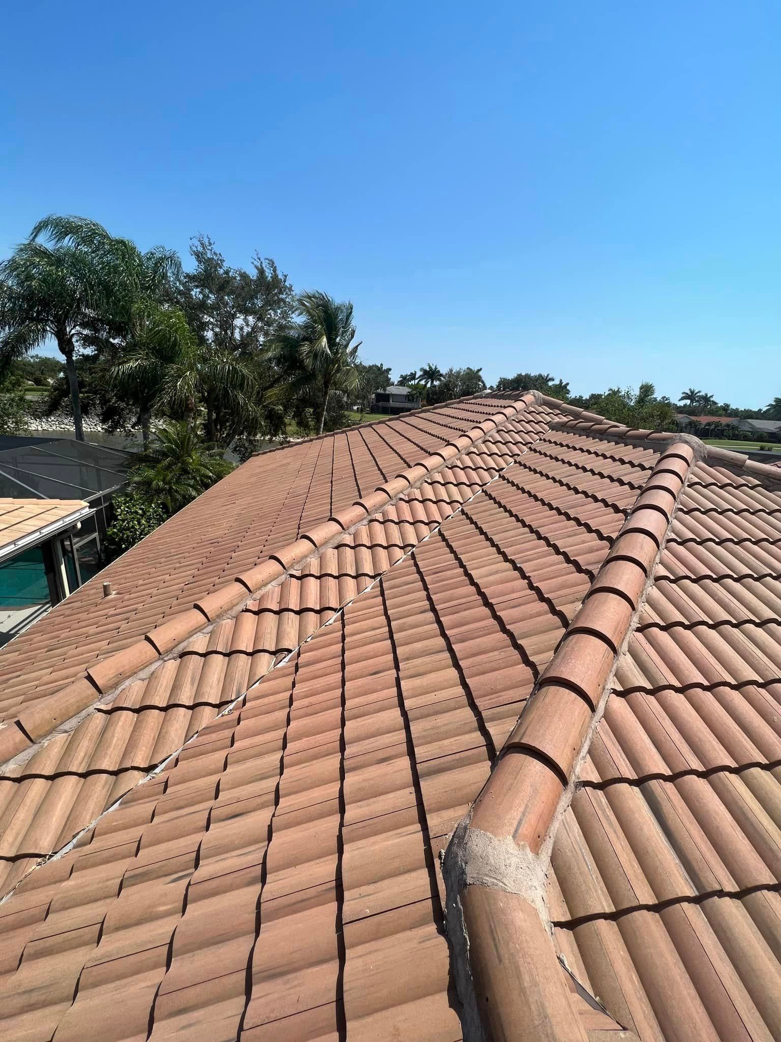 A roof with a lot of tiles on it and trees in the background.