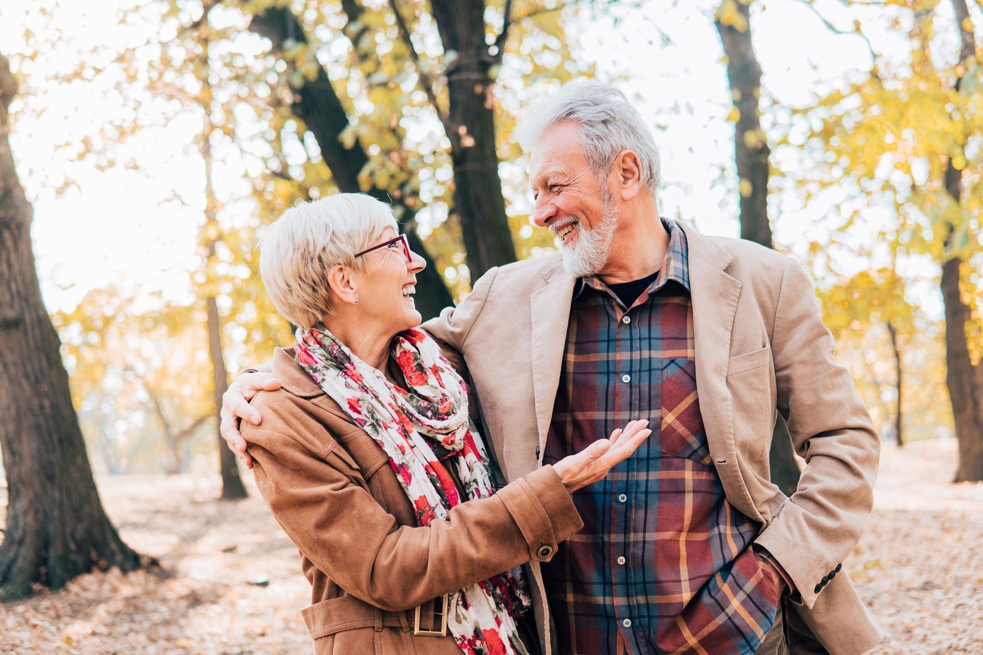A man and a woman are standing next to each other in a park.