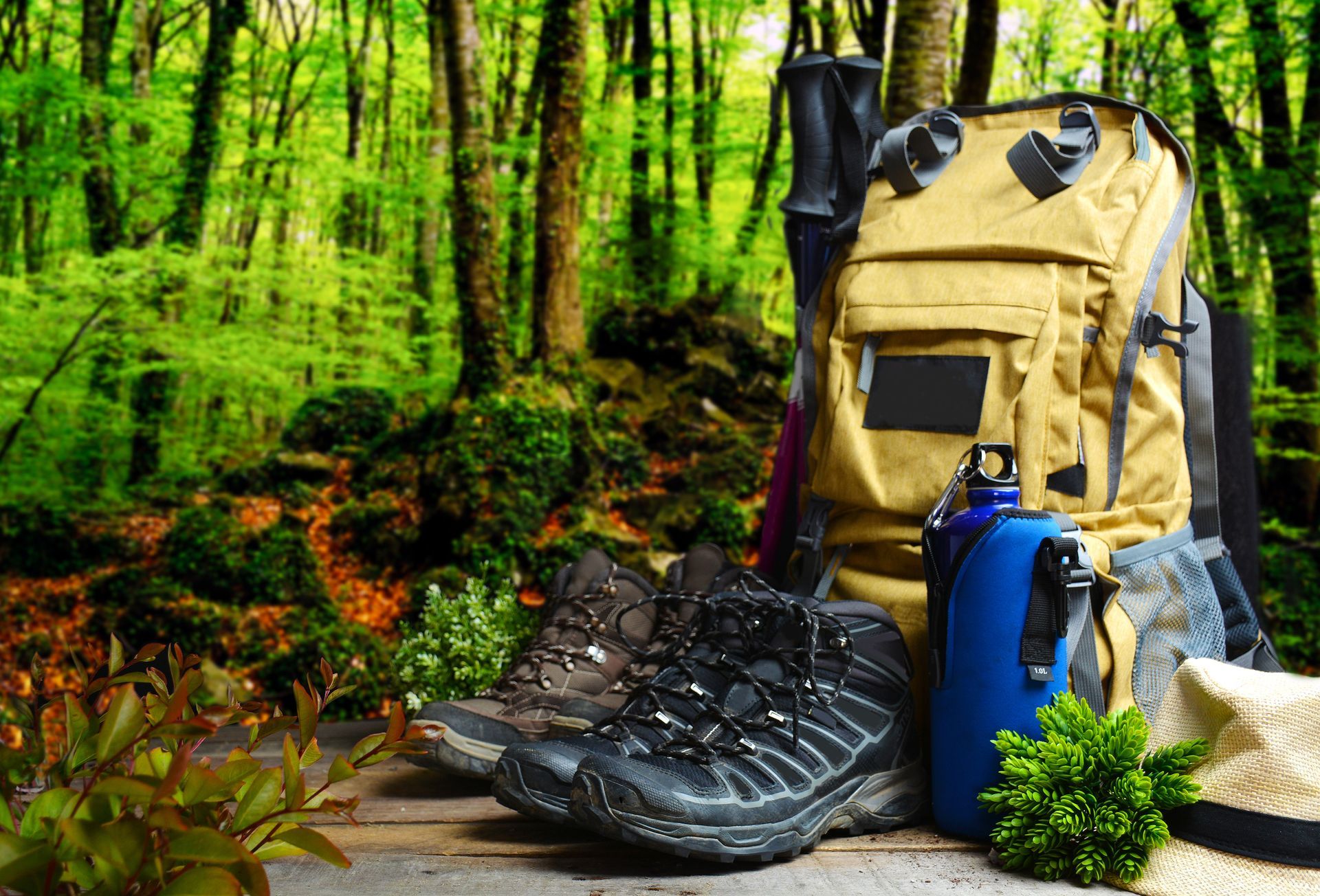 A backpack , hiking boots , a water bottle and a hat are sitting on a wooden table in the woods.