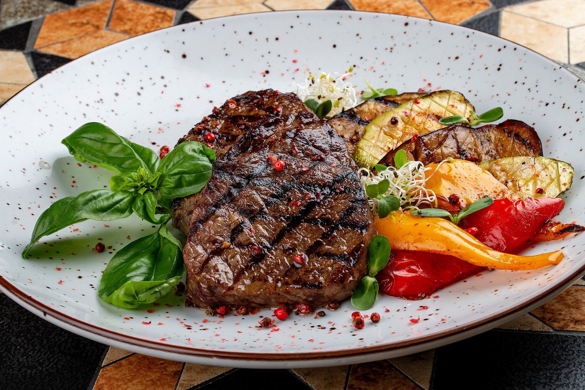 A white plate topped with a steak and vegetables.