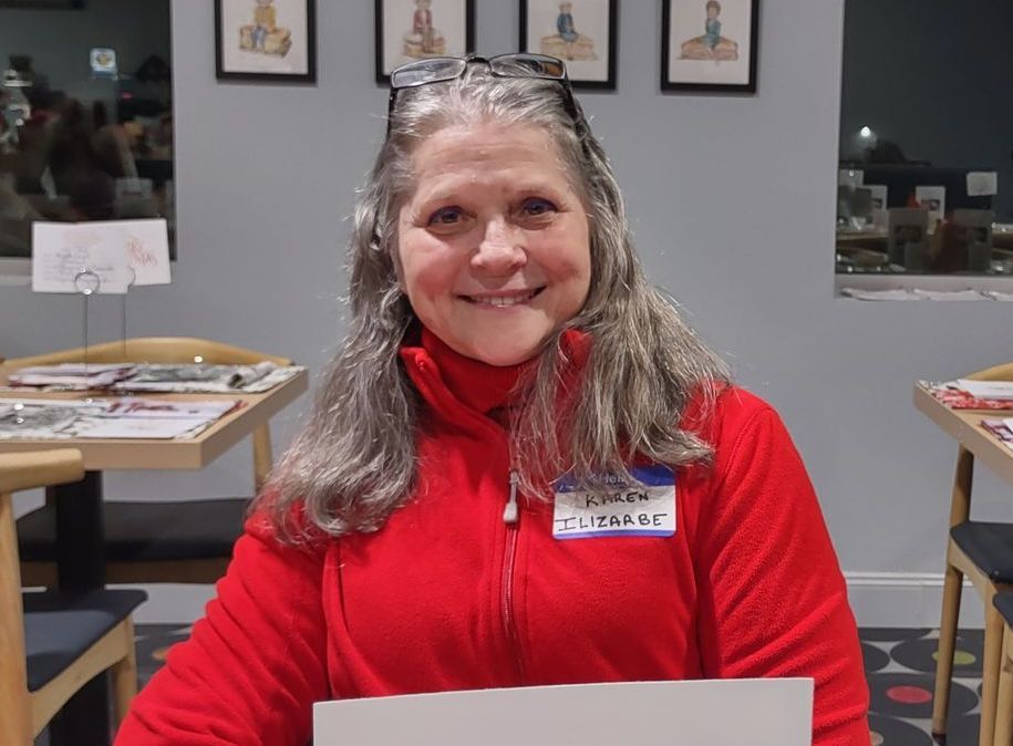 A woman in a red jacket is holding a piece of paper