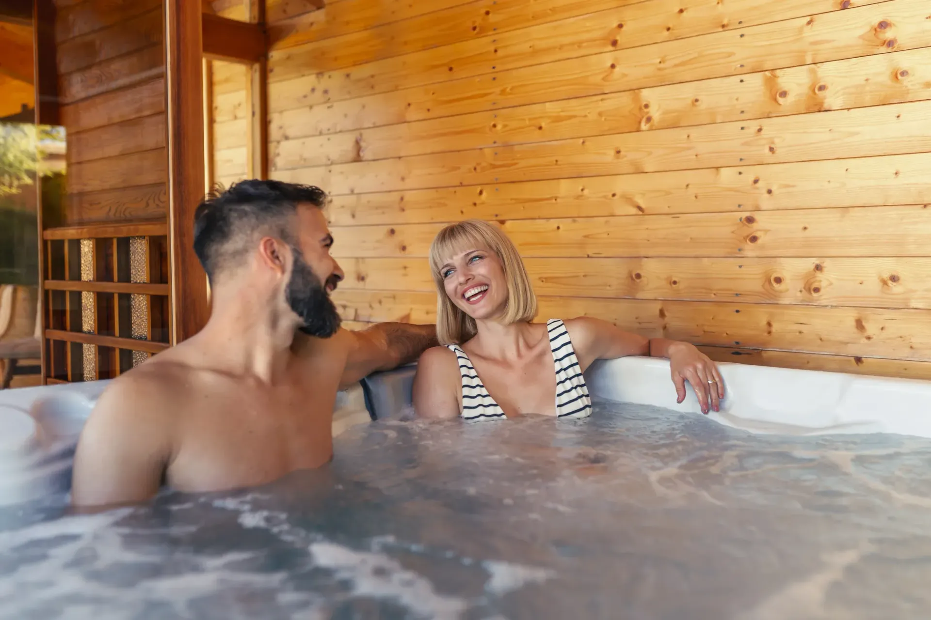 A man and a woman are sitting in a hot tub.