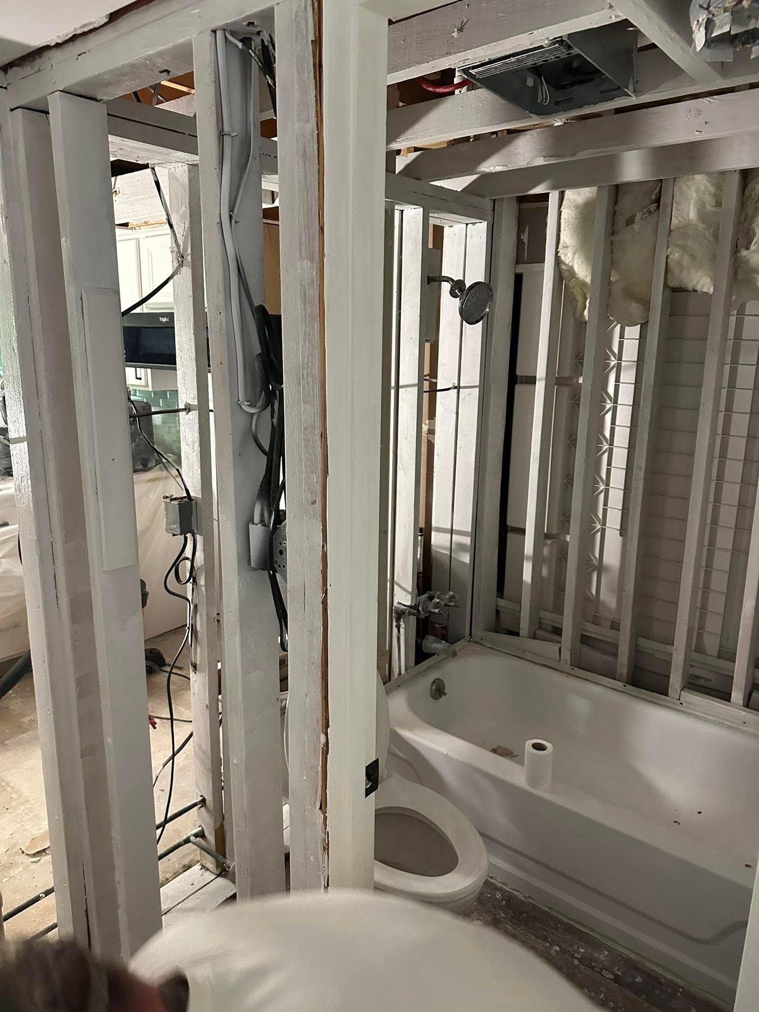 Interior wooden framing of a building under construction; doorways, a window, and exposed studs.
