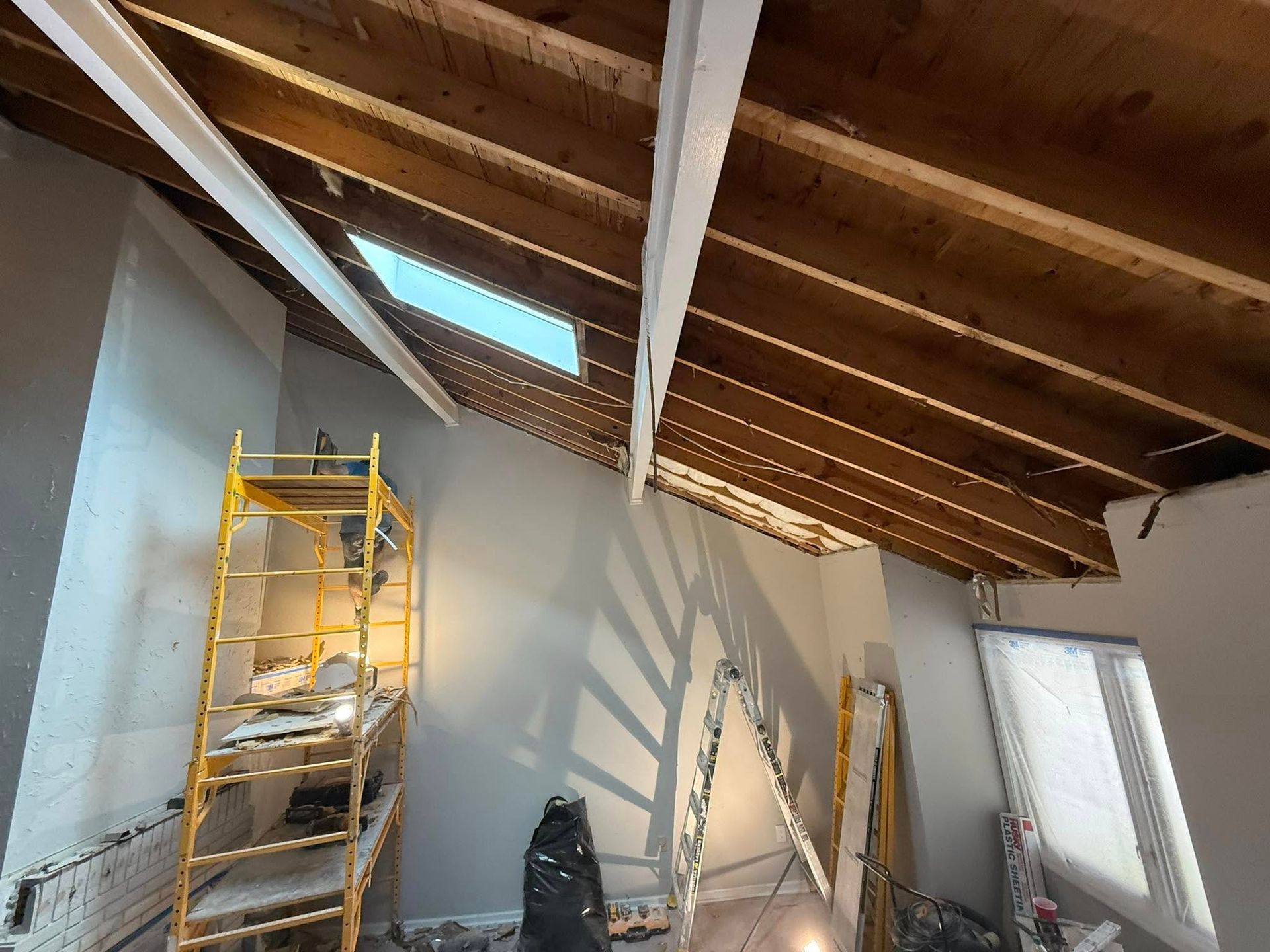 Person using a screwdriver to install a lock on a white door, indoors.