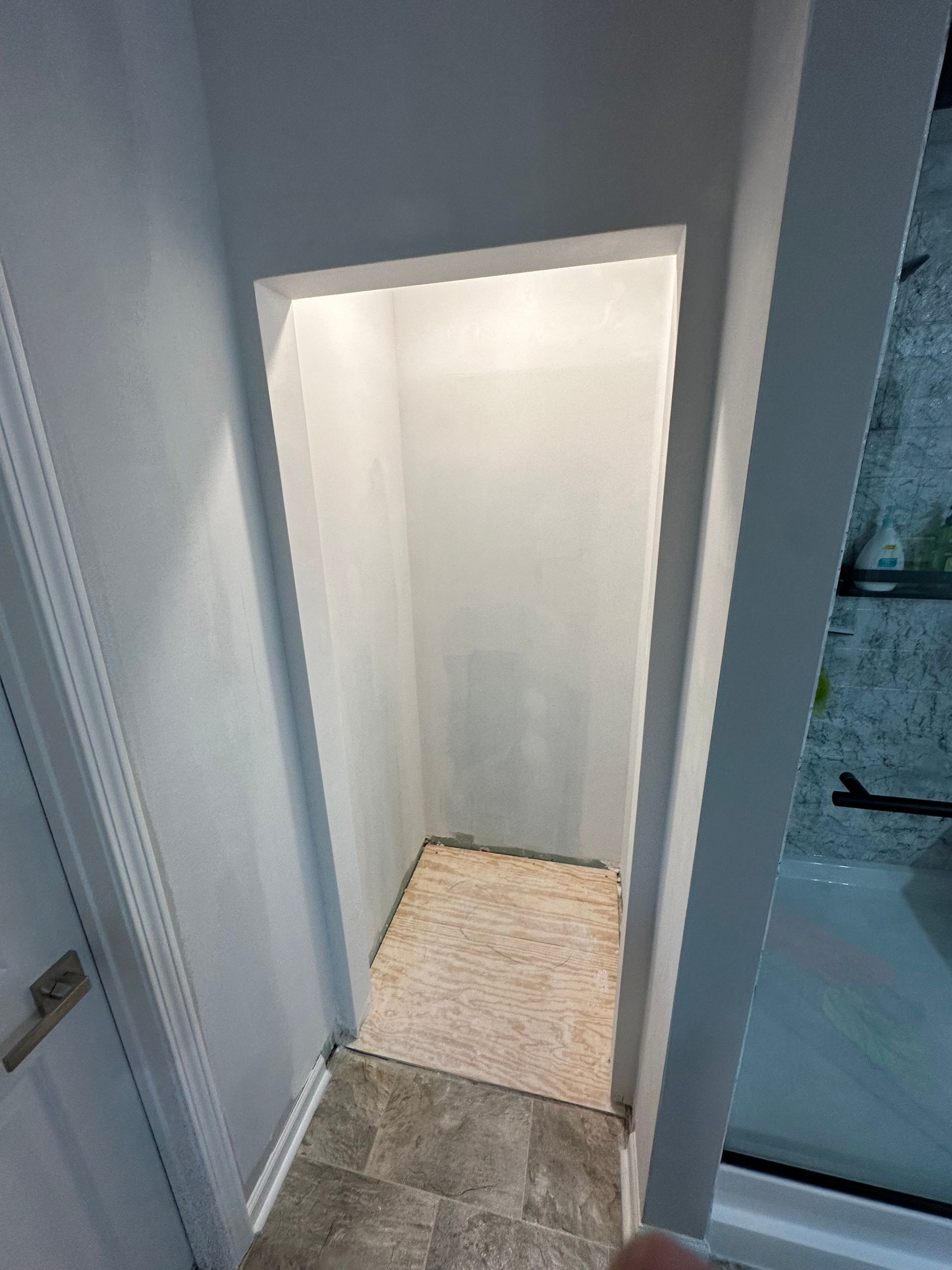 Recessed alcove in a hallway with light-colored walls and flooring.
