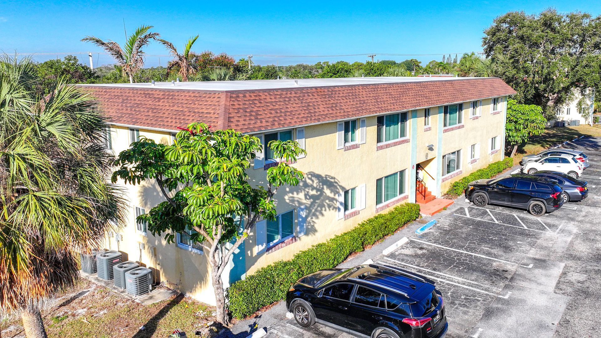 Photo of the apartment complex seen from the parking lot and from a heigh slightly above the building