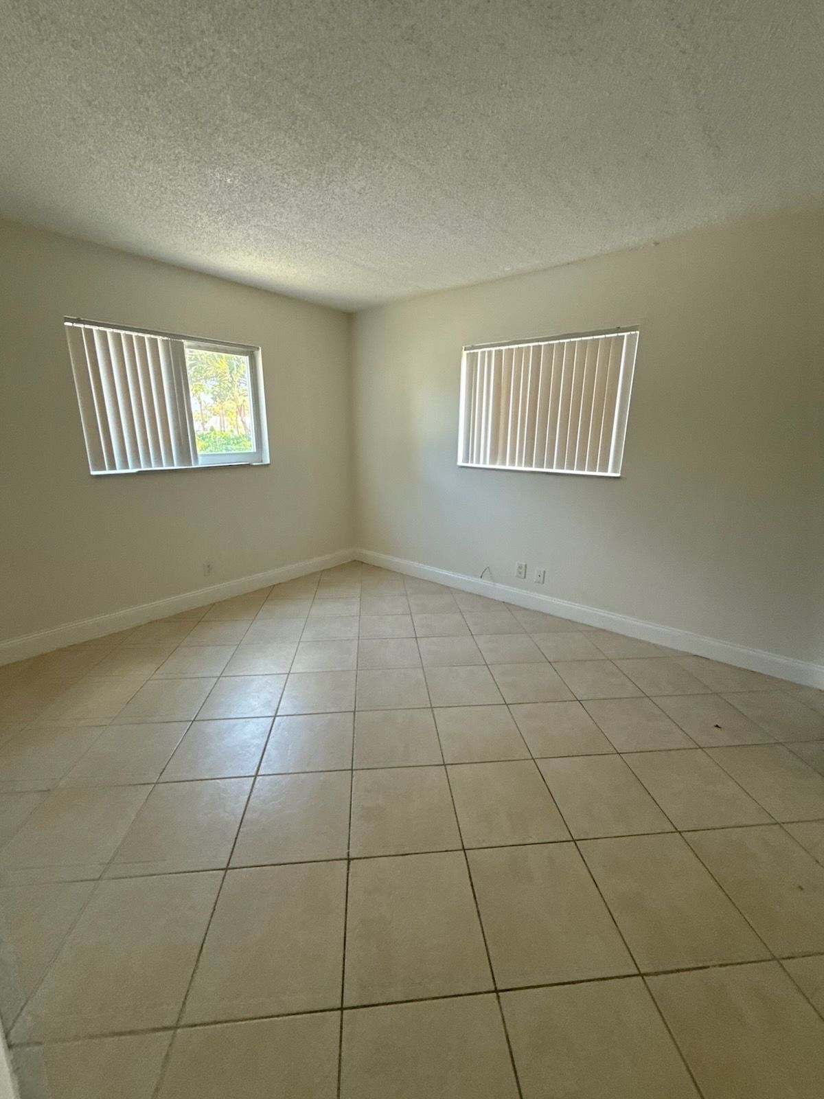 Photo of a room with a window on one wall and another window on the conjoining wall