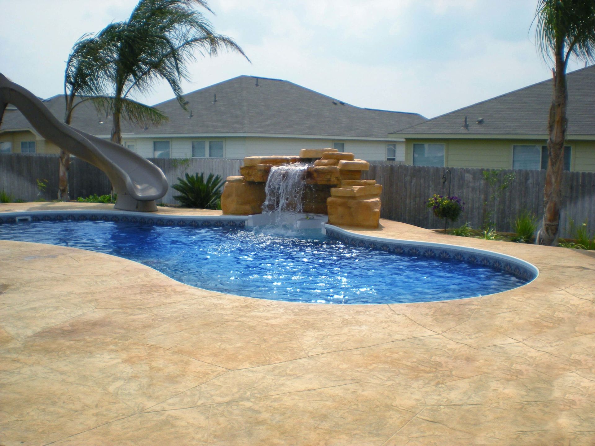 A swimming pool with a waterfall and a slide