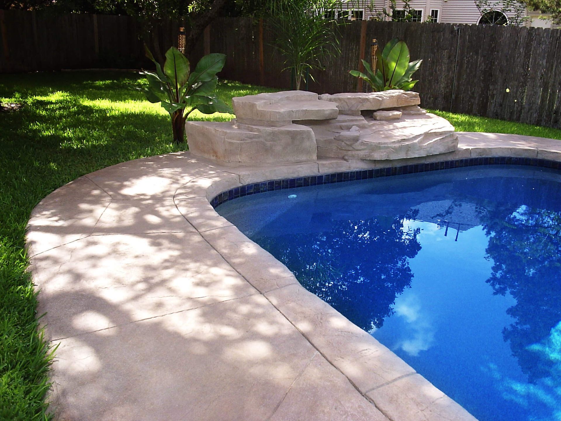A large swimming pool with a fence in the background