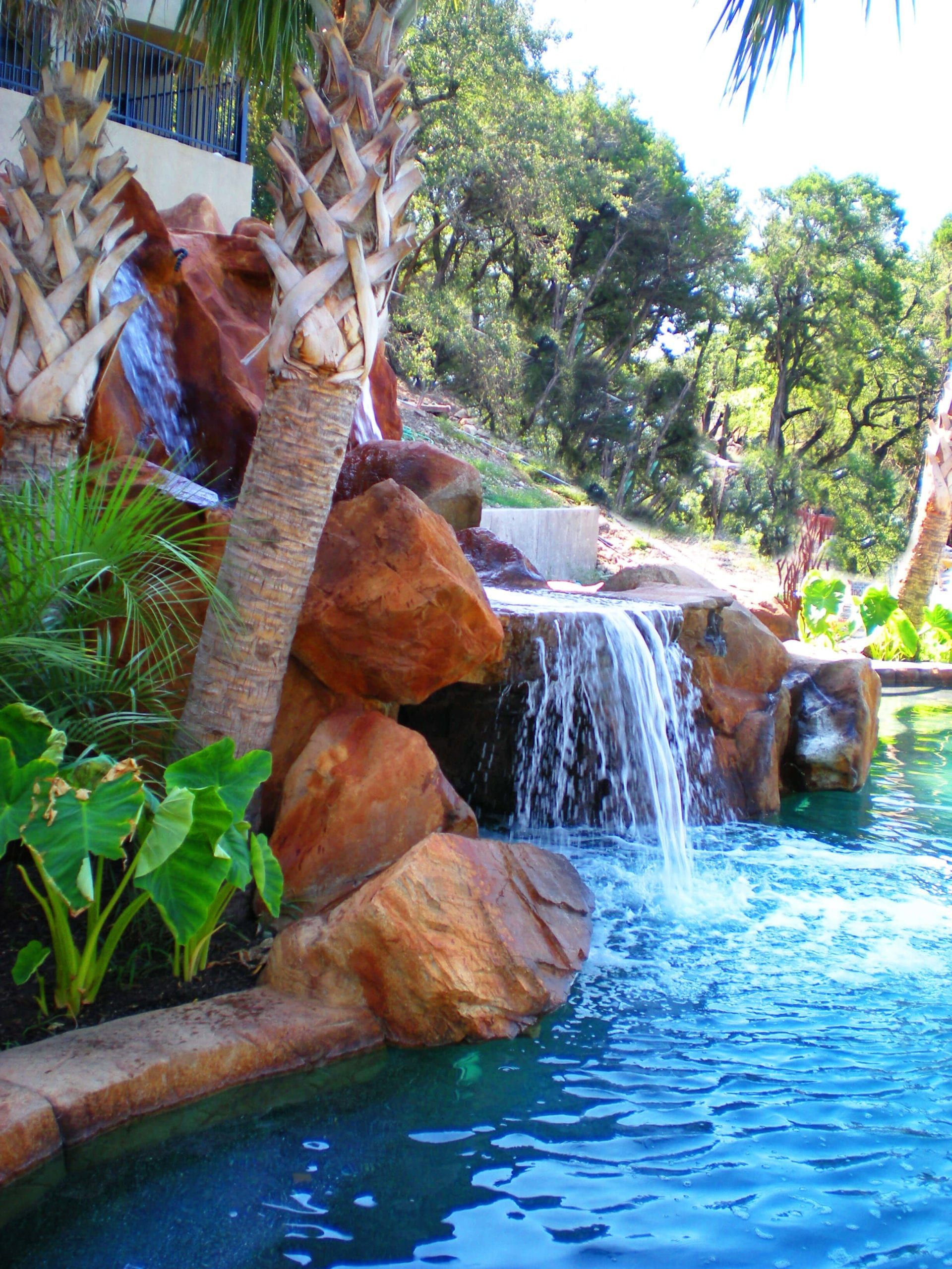 A waterfall is in the middle of a swimming pool