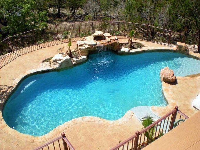 A large swimming pool with a waterfall in the middle