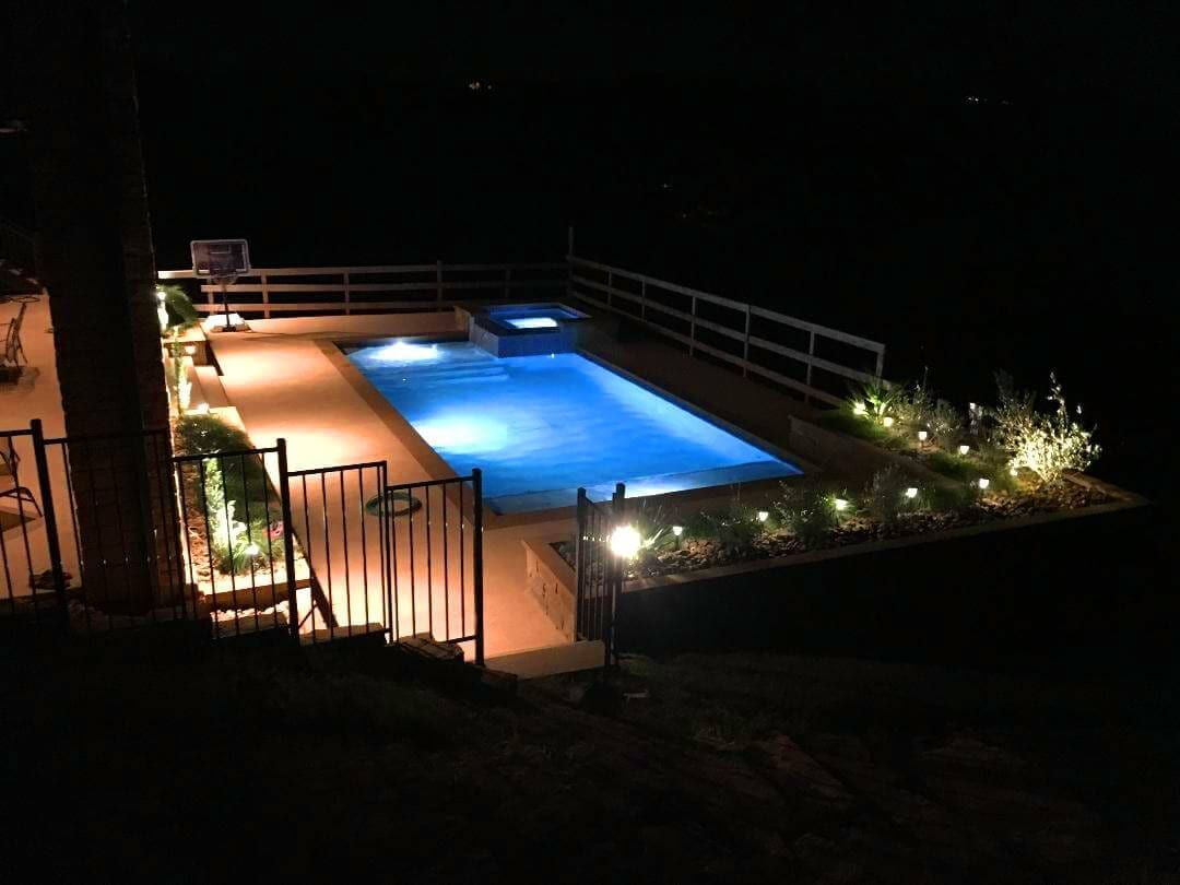 A large swimming pool is lit up at night.