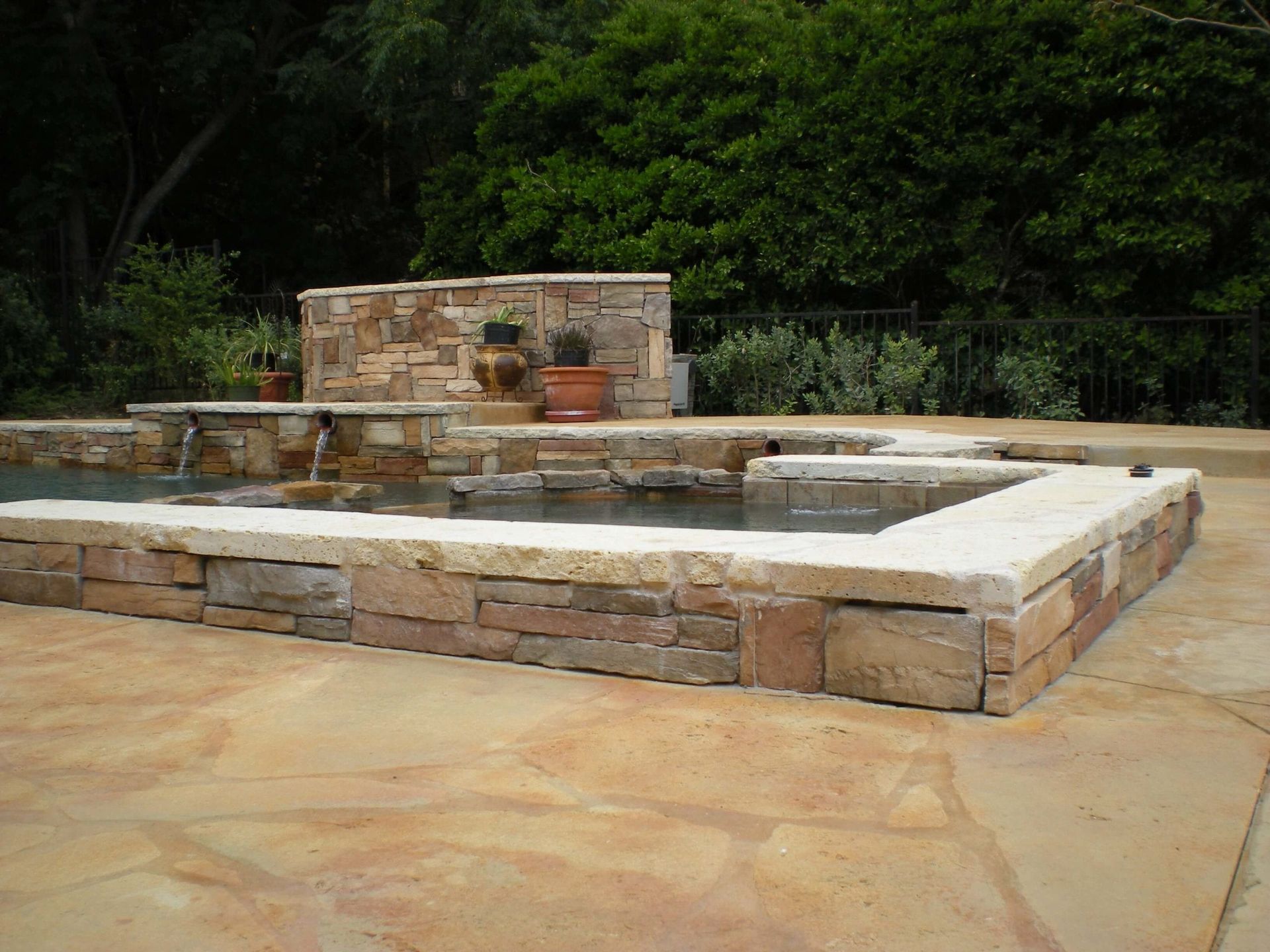 A swimming pool with a fountain in the middle of it