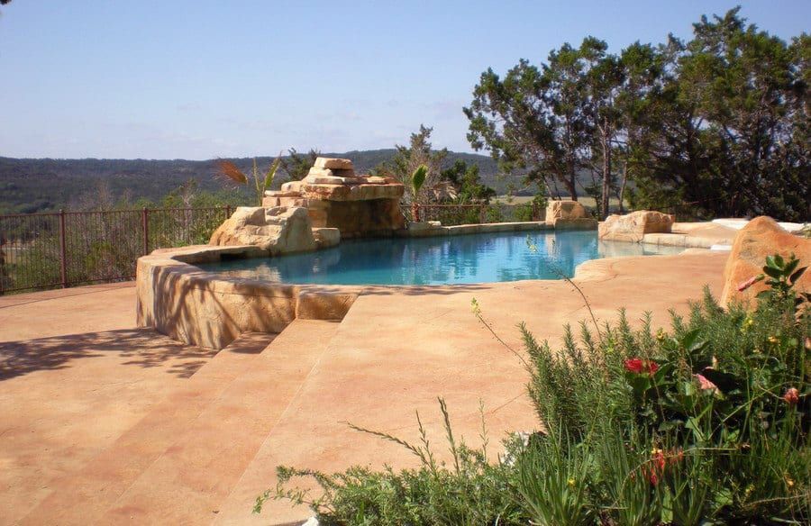 A large swimming pool with a waterfall in the background