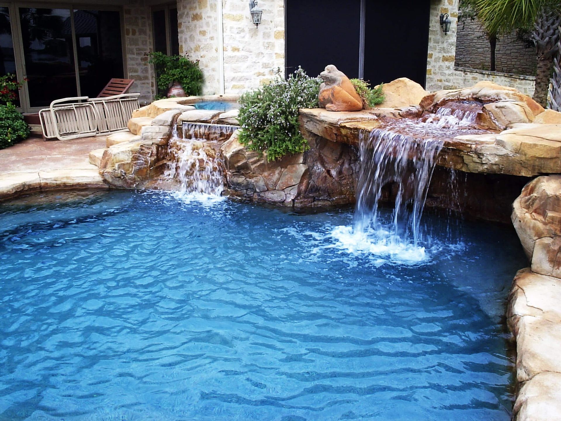 A large swimming pool with a waterfall in the middle