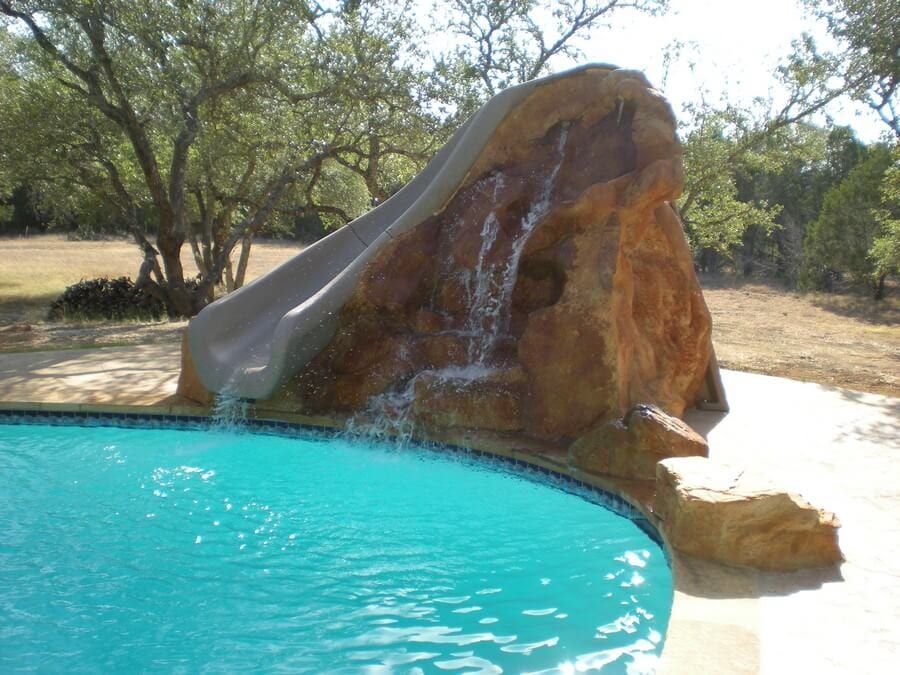 A swimming pool with a water slide and a waterfall