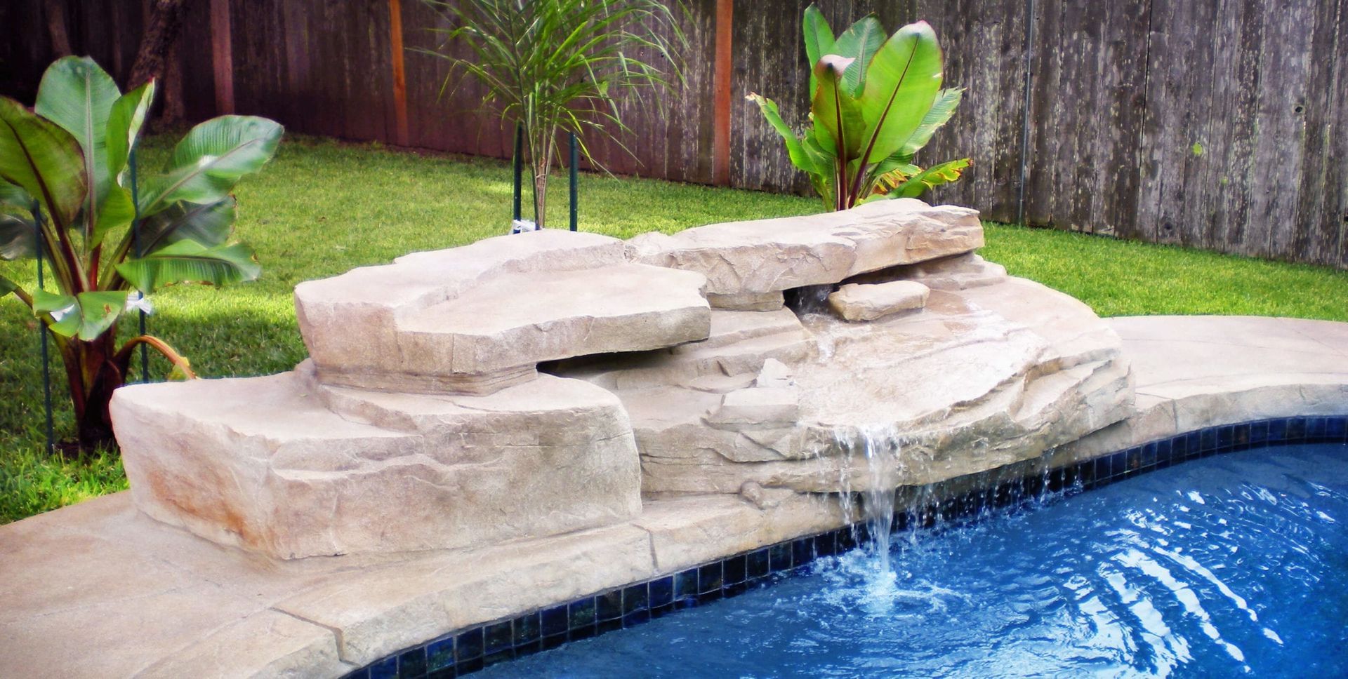 A swimming pool with a waterfall in the middle of it.