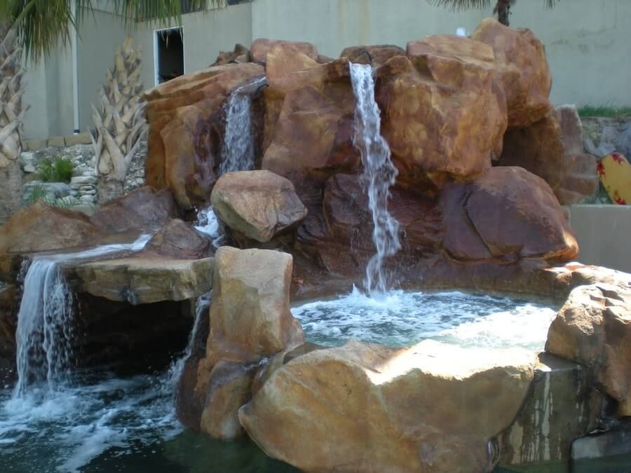 A waterfall is surrounded by rocks and a pool of water