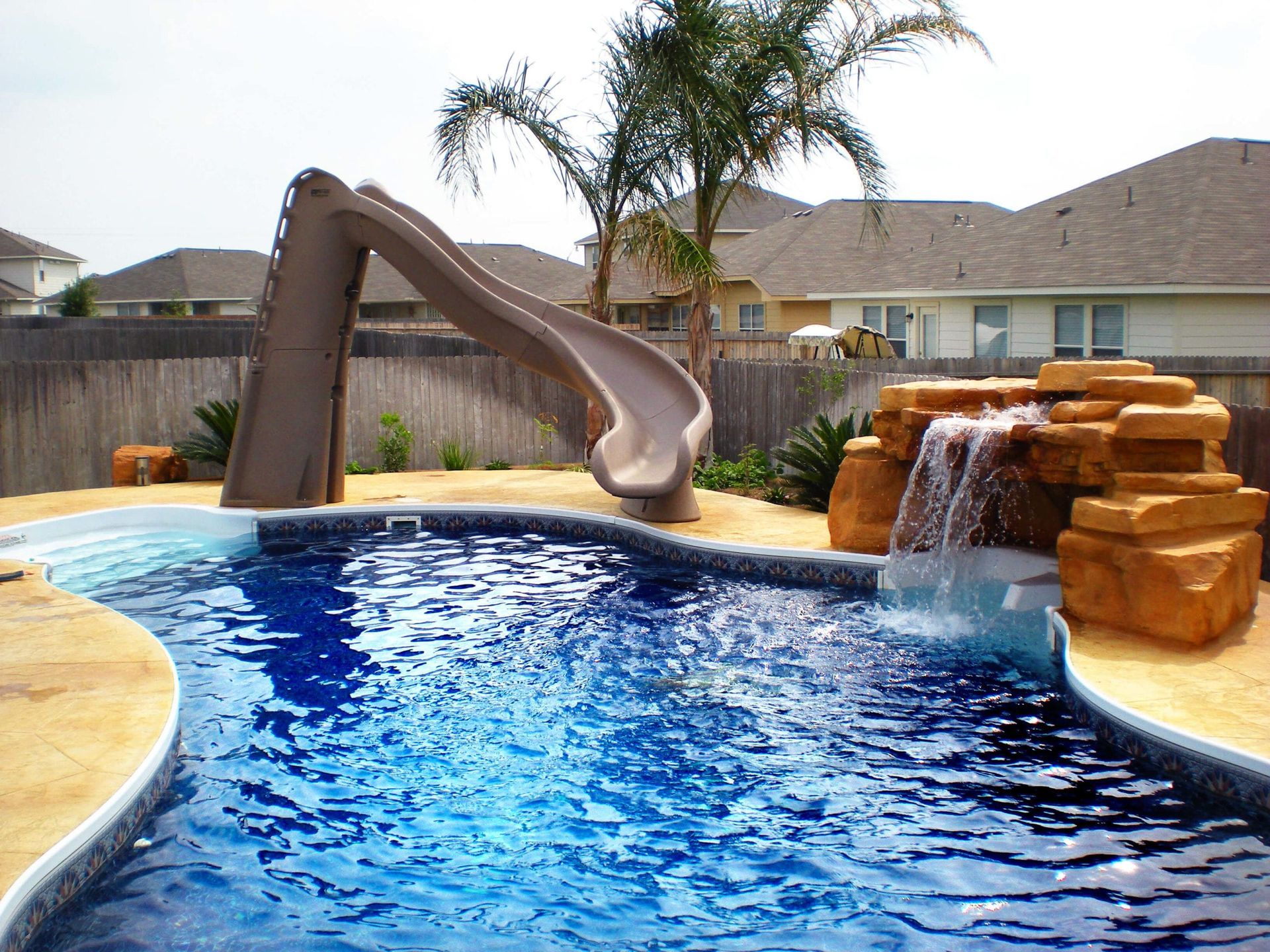 A swimming pool with a slide and a waterfall