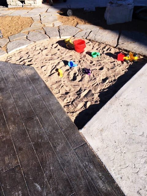 A sandbox with buckets and shovels in it