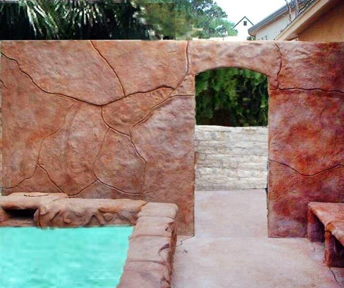 A swimming pool with a stone wall surrounding it