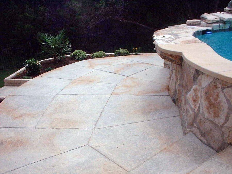 A patio with a swimming pool in the background