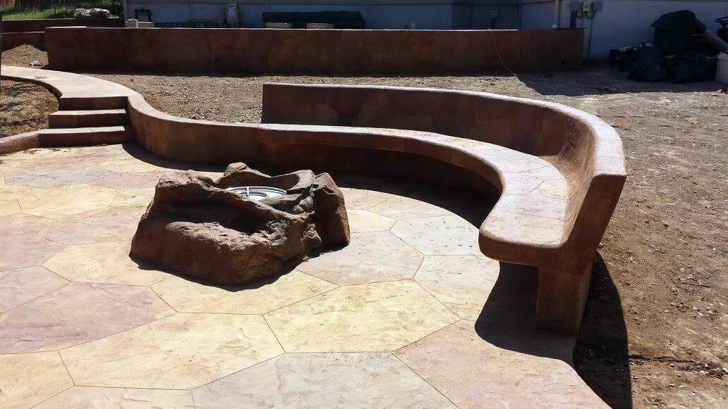 A curved bench sits next to a fire pit