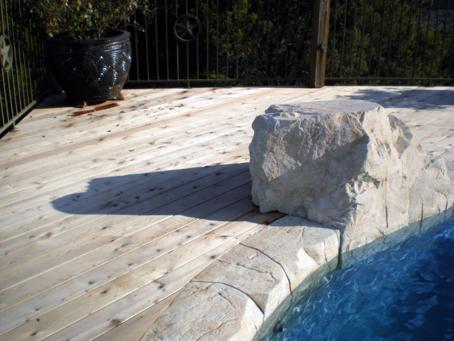 A large rock sits on the edge of a swimming pool