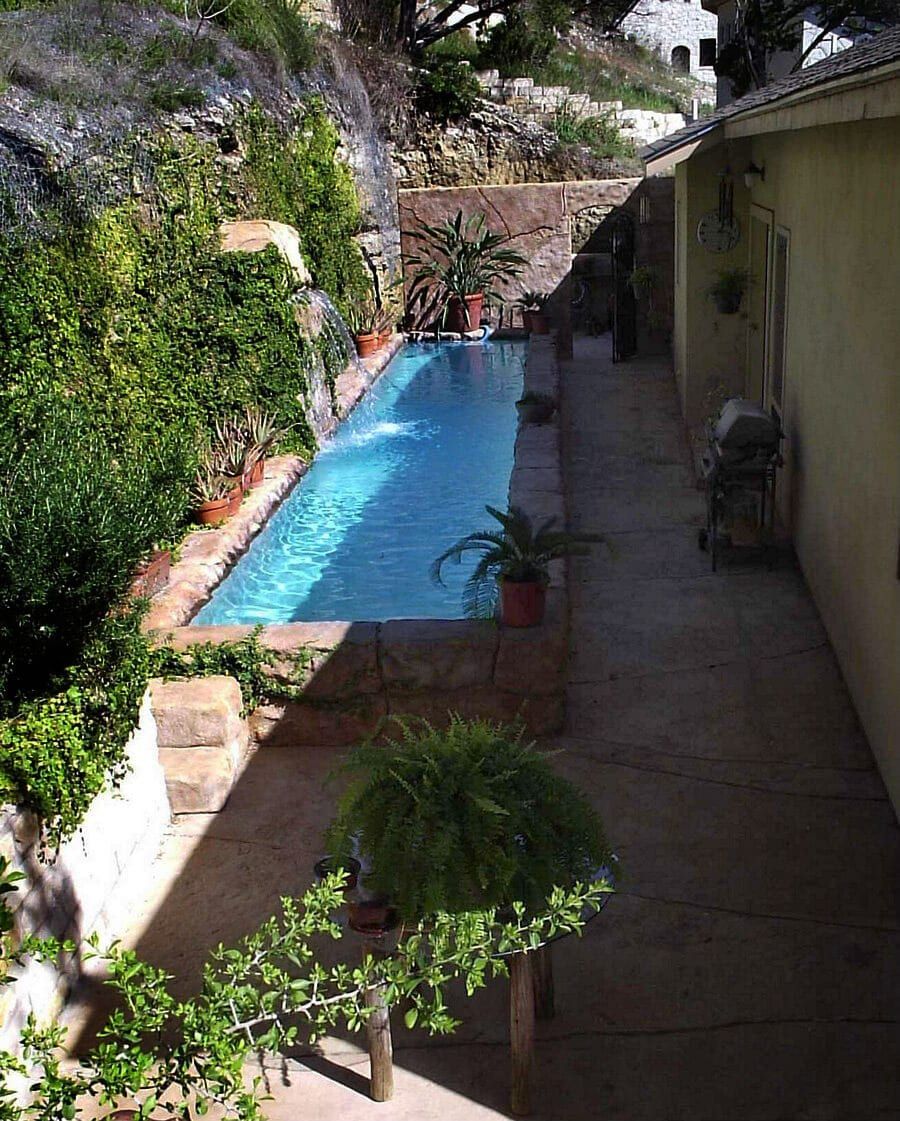 A large swimming pool is in the backyard of a house