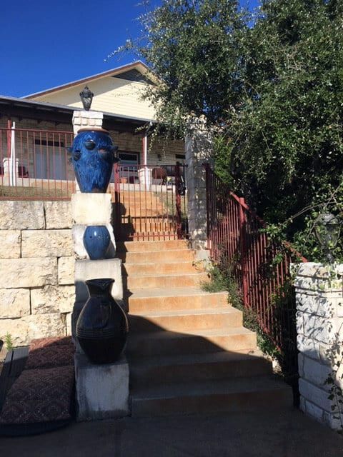 A set of stairs leading up to a house with blue vases on top of them