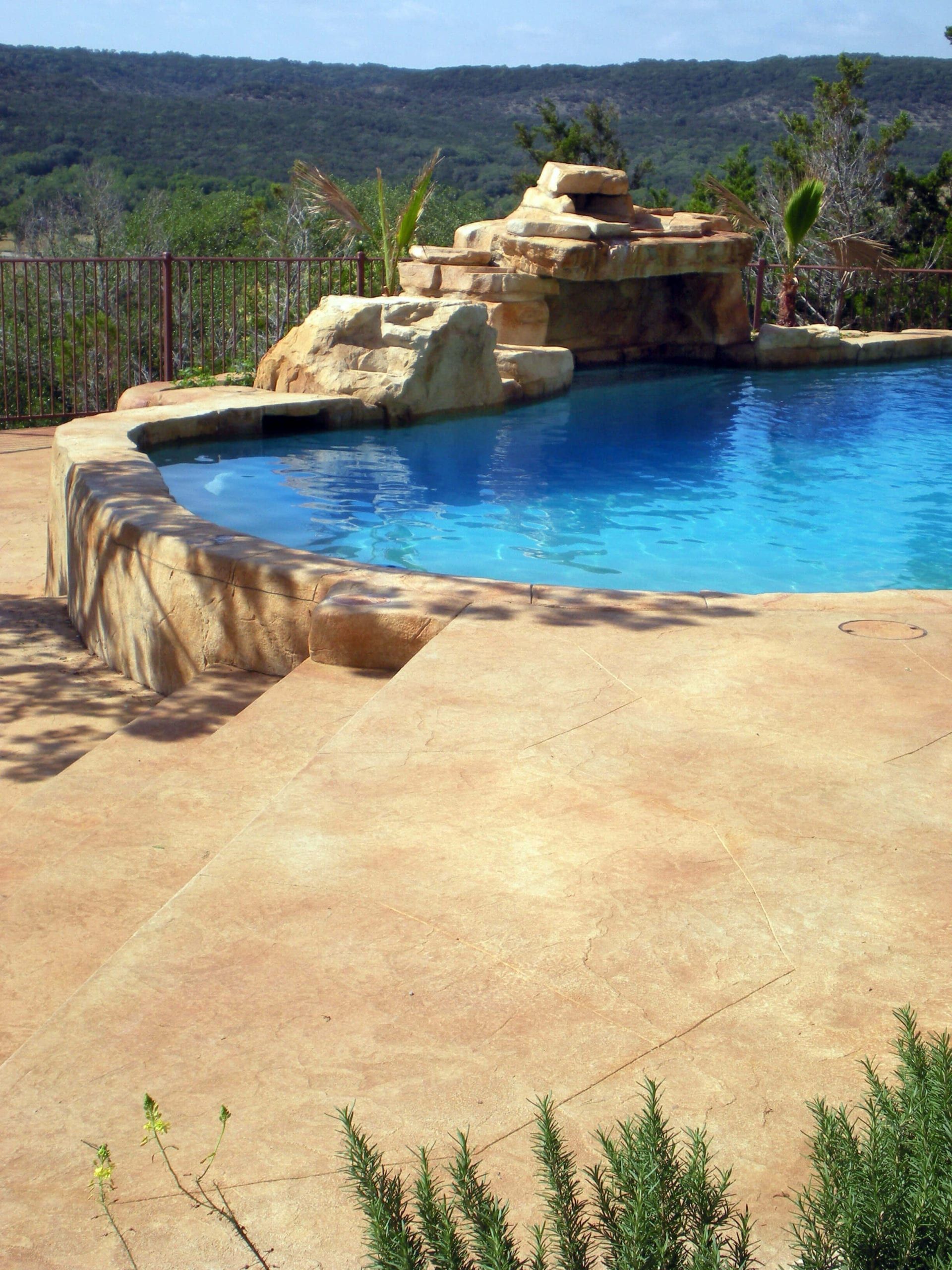 A large swimming pool with a waterfall in the background