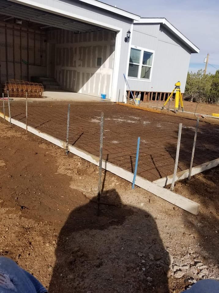 A person is sitting in front of a house under construction.