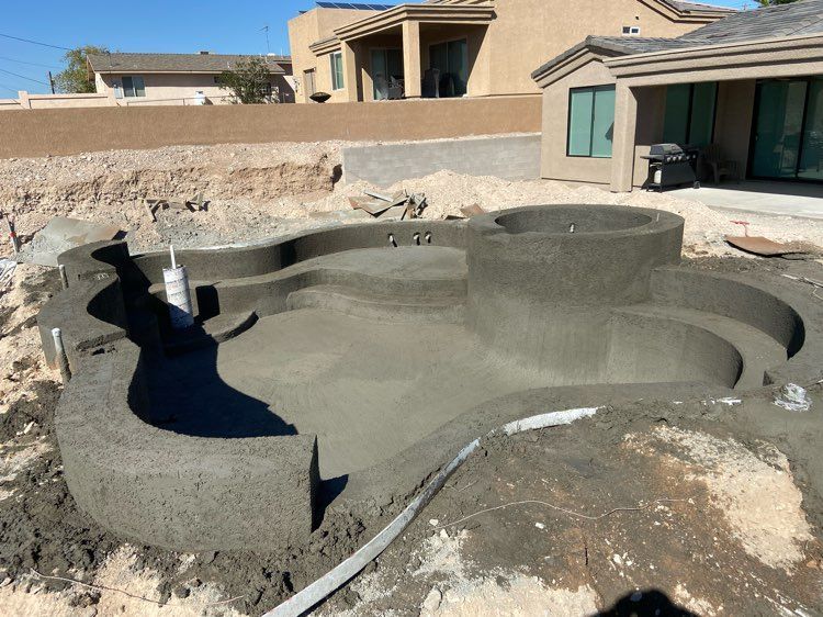 A swimming pool is being built in the backyard of a house