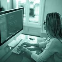 A woman is sitting at a desk using a computer.