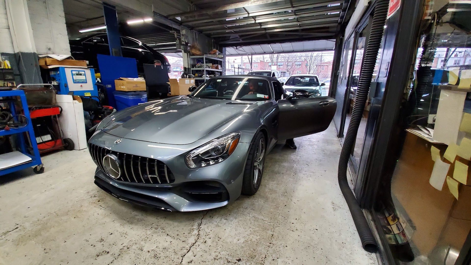 Gray sports car with open door in a garage. | Kraft German Auto