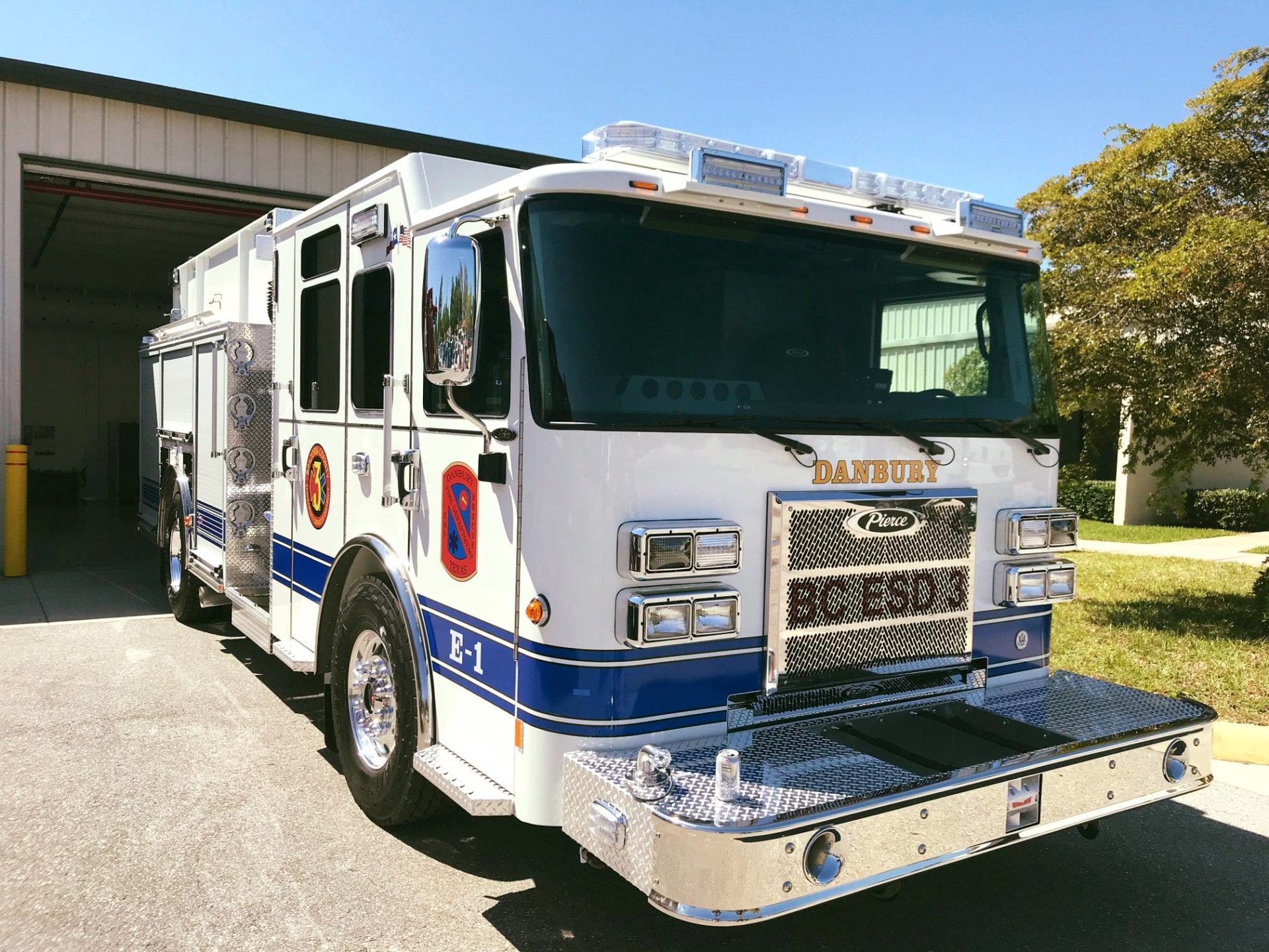 A white and blue fire truck is parked in front of a building.