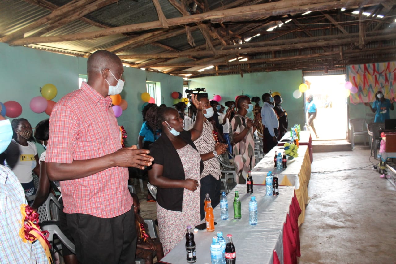A group of people are standing around a table in a room.