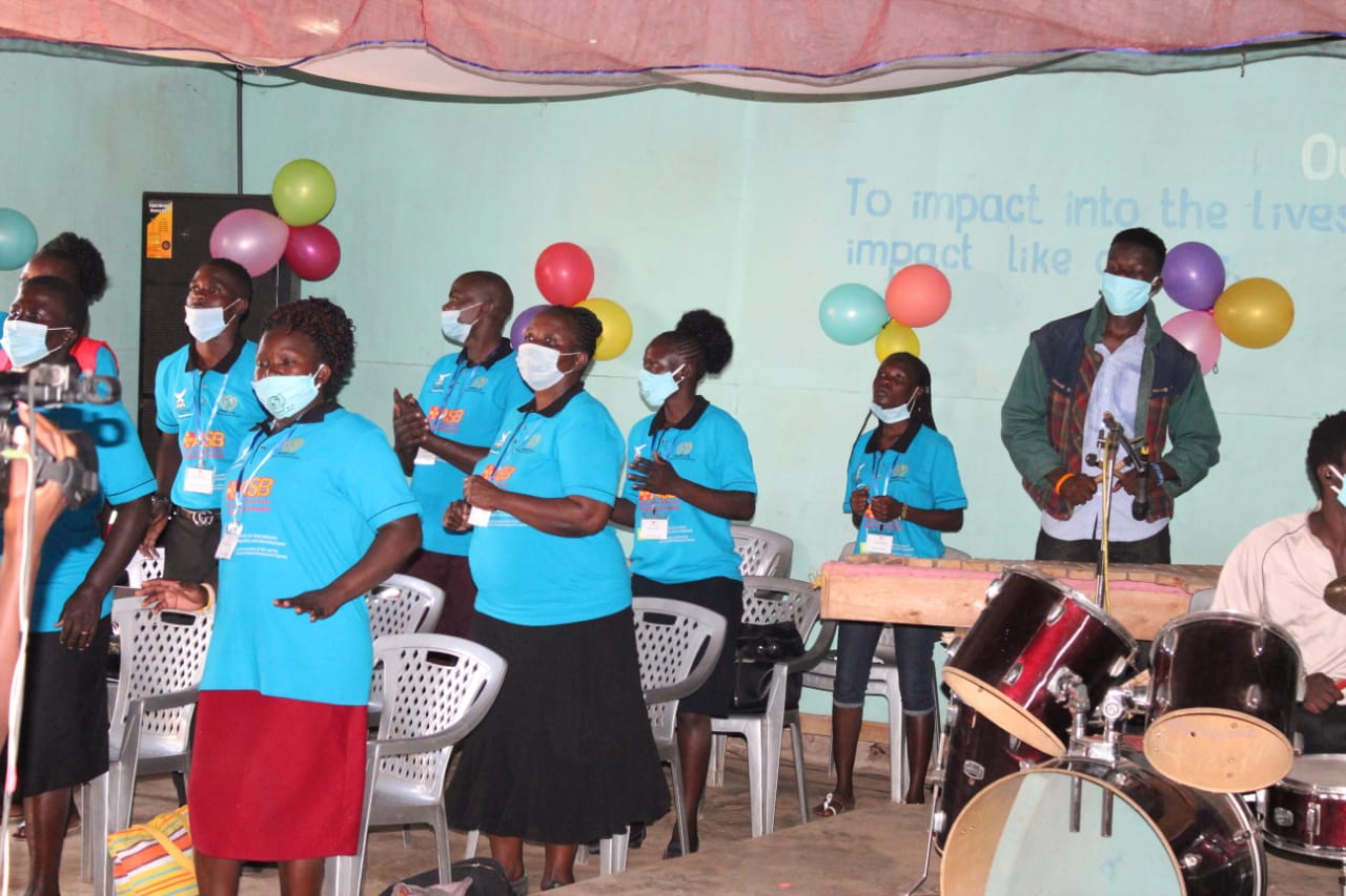 A group of people wearing face masks are standing in front of a drum set