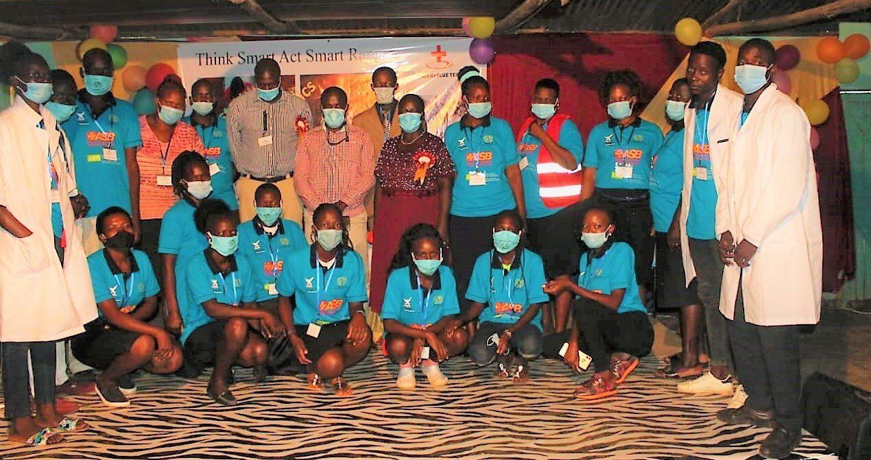 A group of people wearing masks are posing for a picture.